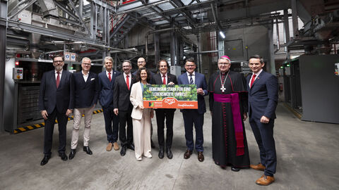 Zehn Personen stehen in einer Industriehalle. Drei Personen, darunter auch Ministerpräsident Boris Rhein, halten ein Plakat hoch mit der Aufschrift "Gemeinsam stark für eine lebenswerte Umwelt"